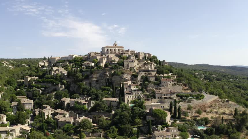 Medieval buildings of the village of gordes built on a mountain with mountains in the distance
