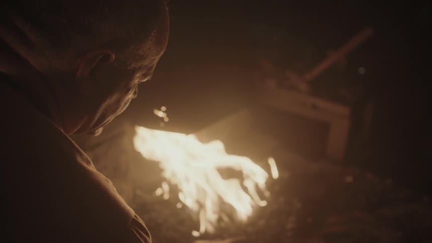A blacksmith is  tending to his fire