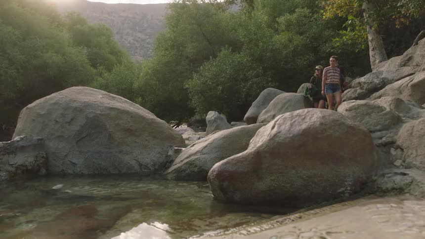 A group of friends hiking near a rippling lake in nature