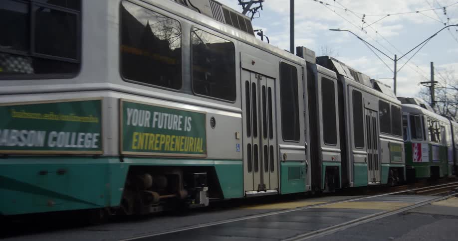Urban electric train crossing a road in the city street at morning