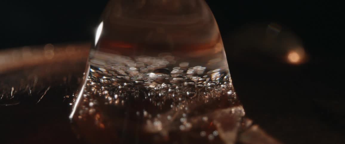 Translucent clear fluid with several small bubbles shimmies but doesnot disperse due to surface tension