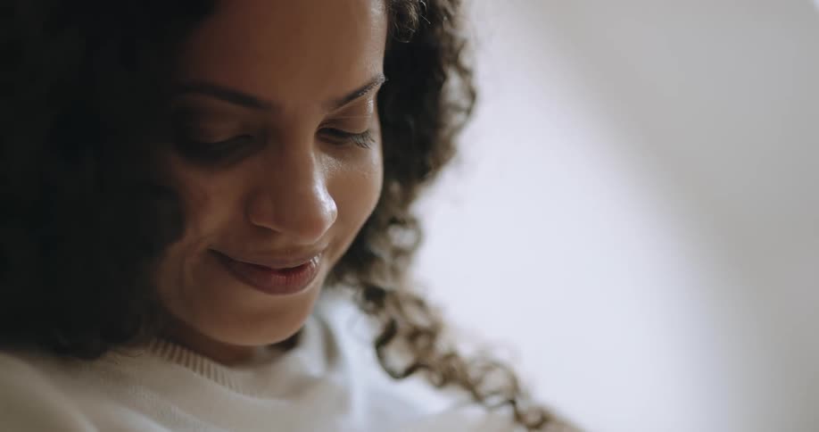 A woman smiles and looks down