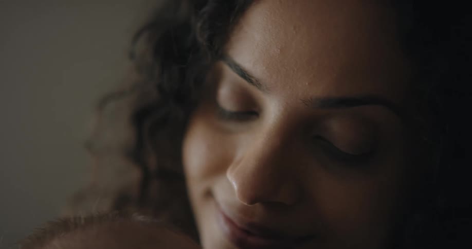 Woman smiles while cuddling baby close