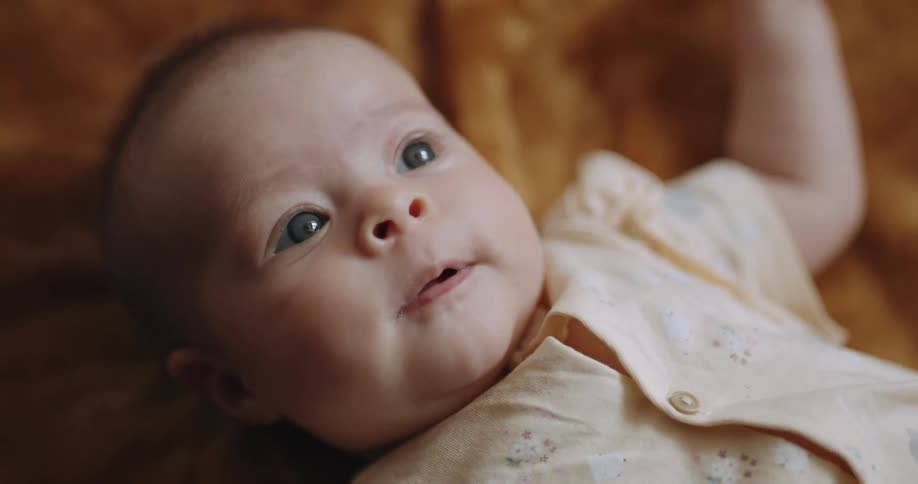 A baby moves around in bed