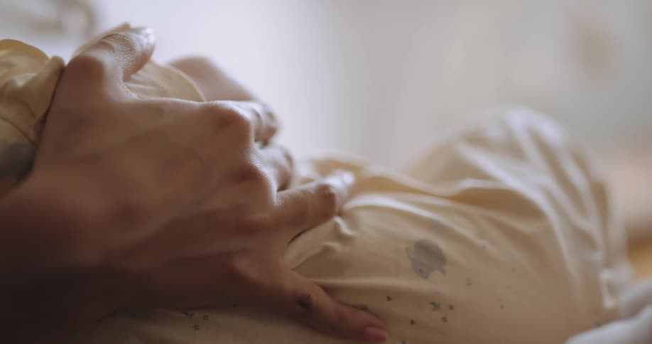 A mom holds her baby close as she breast feeds