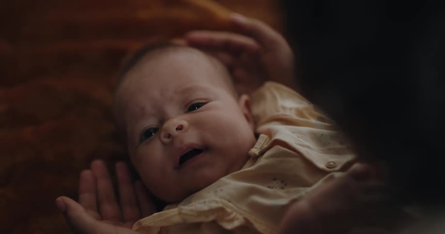 Mom caresses babys head and hands