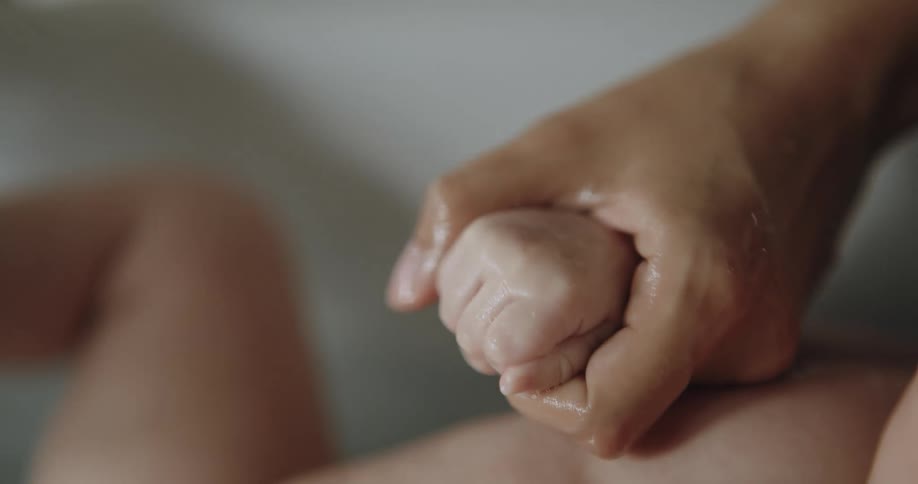 A person is bathing a baby