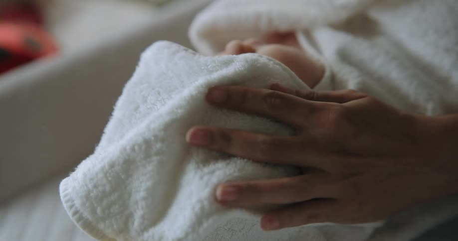 Mother dries babys hair after bath time