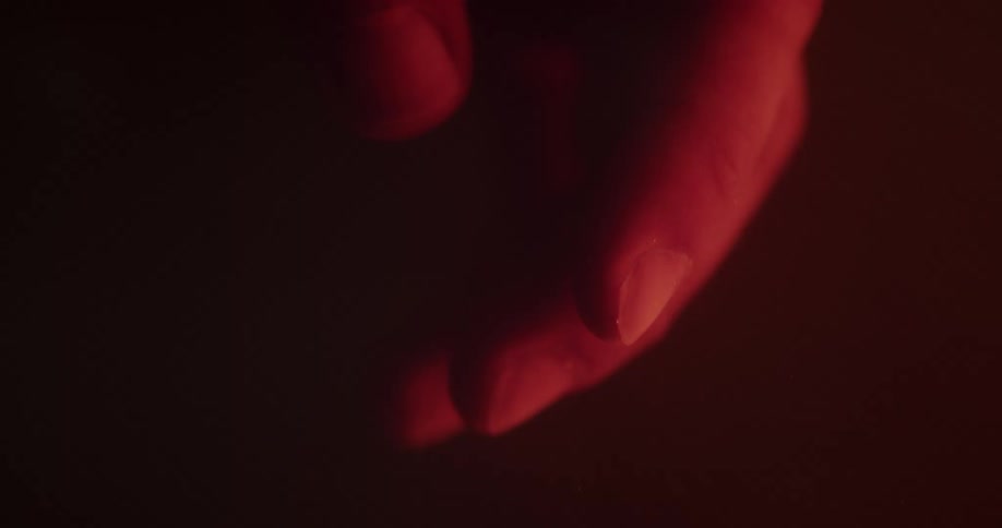 A human hand floating in water in the dark