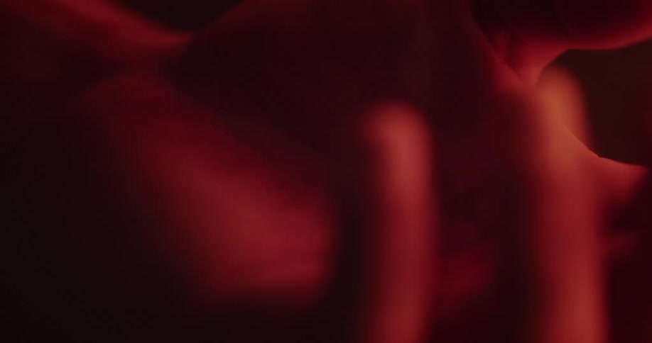 Hand twitches while it floats in red tinted water