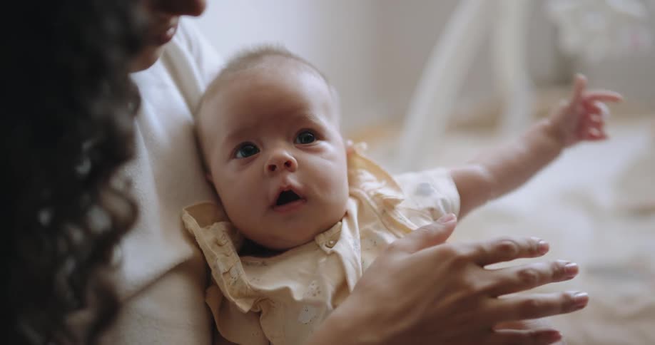 A mother is comforting her tired baby as they yawn