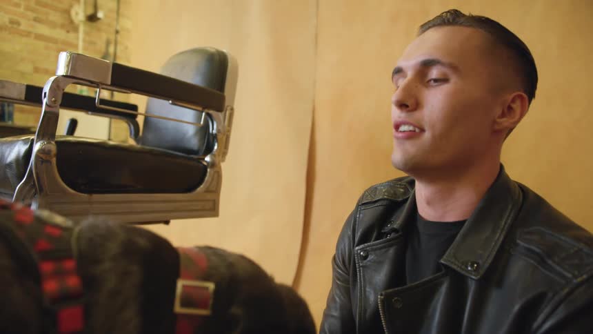 Young man petting his dog in a barber shop