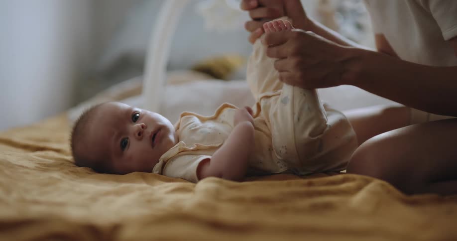 Mother smiles and plays with childs feet