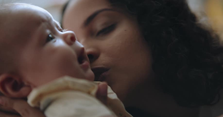 A mother holds and talks to her baby