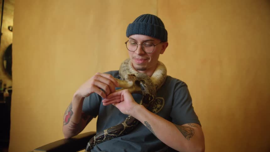 A man is posing with his pet snake