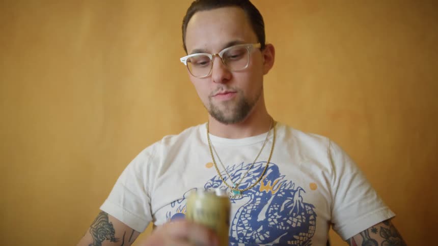 A man is sitting in a chair and drinking a beverage