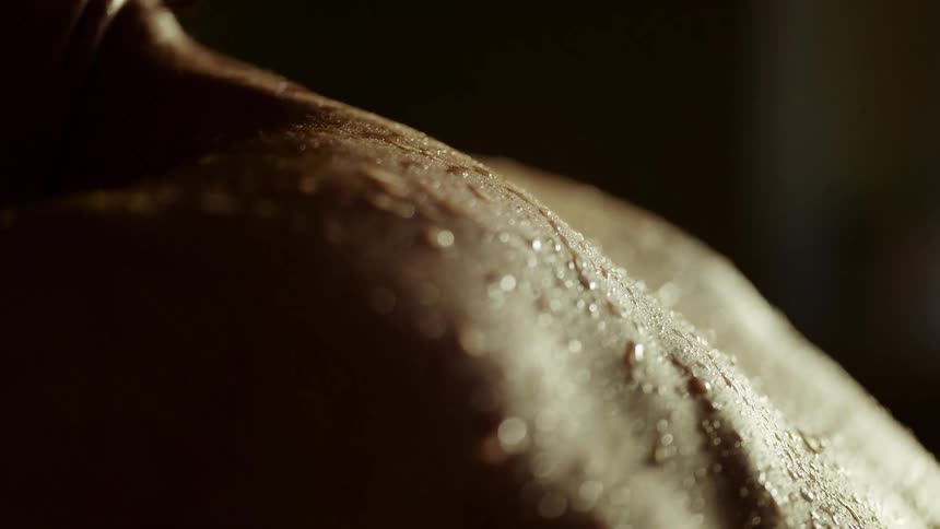 A man in a room with sweat dripping off his back