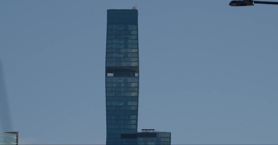 The st regis tower in downtown chicago against a blue sky with a plane flying behind it