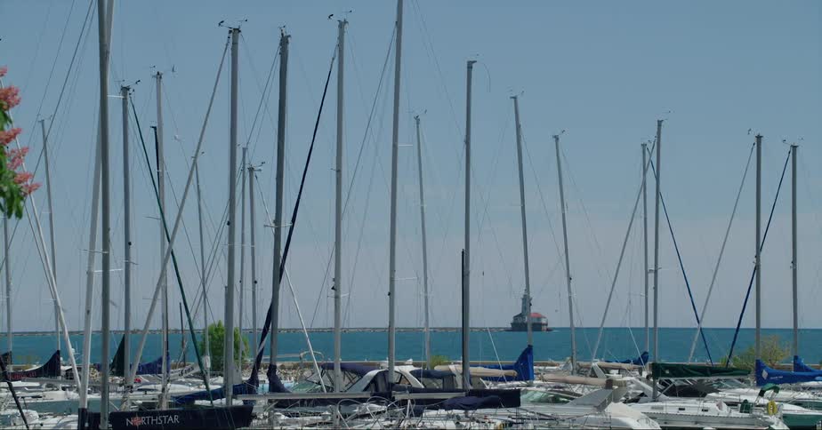 People bike past a marina with boats