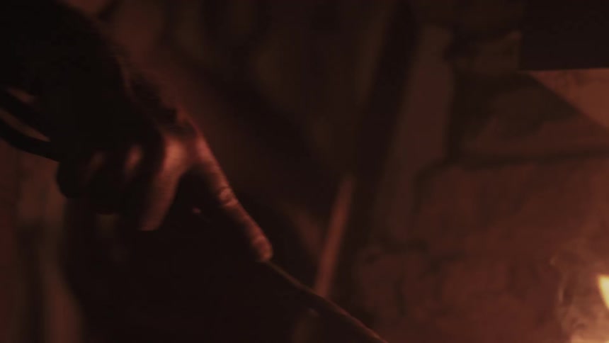 A person is stirring a fire with a hook