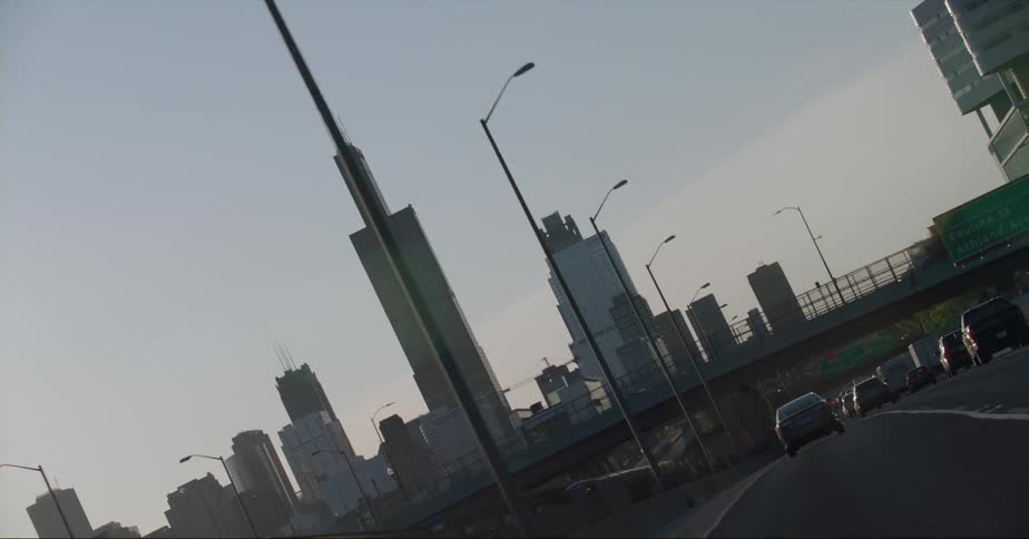Heavy traffic passes under a bridge on a highway headed toward downtown