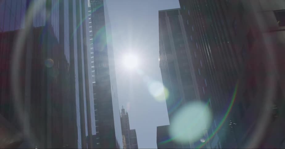 The sun shining down on high rise office buildings in a city