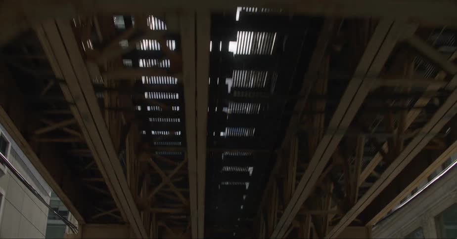 A passenger train travels on an elevated track through a city