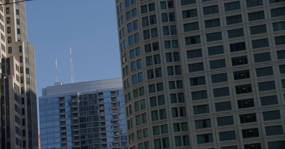 Some downtown skyscrapers reflect others under a clear sky