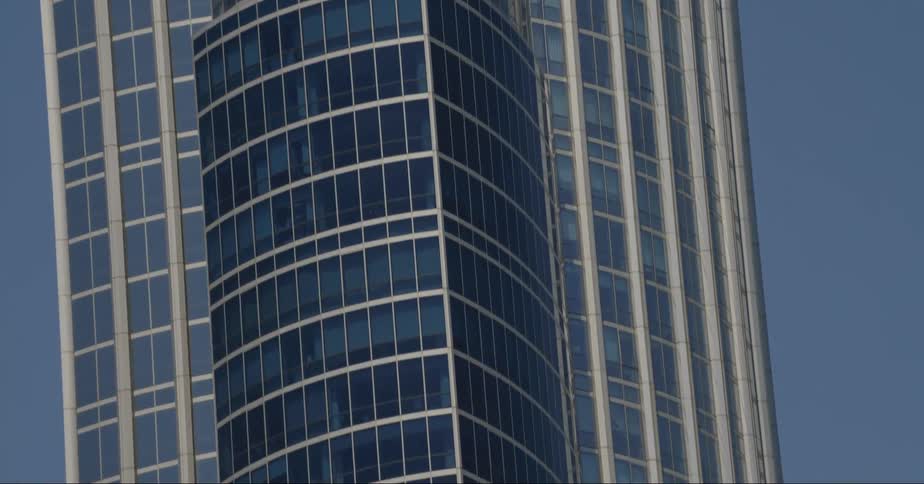 Sunny skies reflect off the mirrored windows of a high rise building