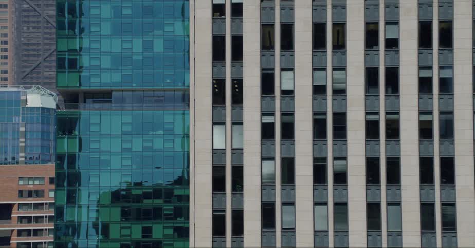 Adjacent skyscrapers reflect off the mirrored windows of a high rise building