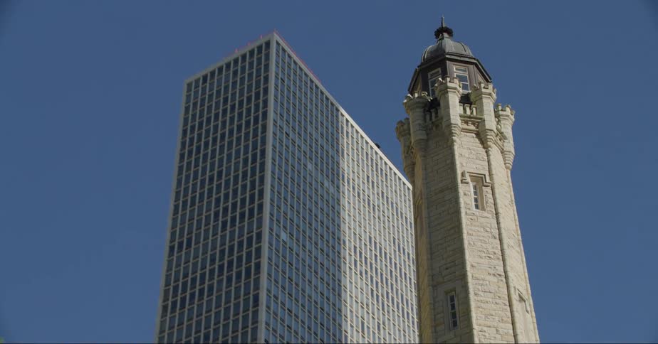 A narrow domed skyscraper is flanked by taller and wider buildings downtown