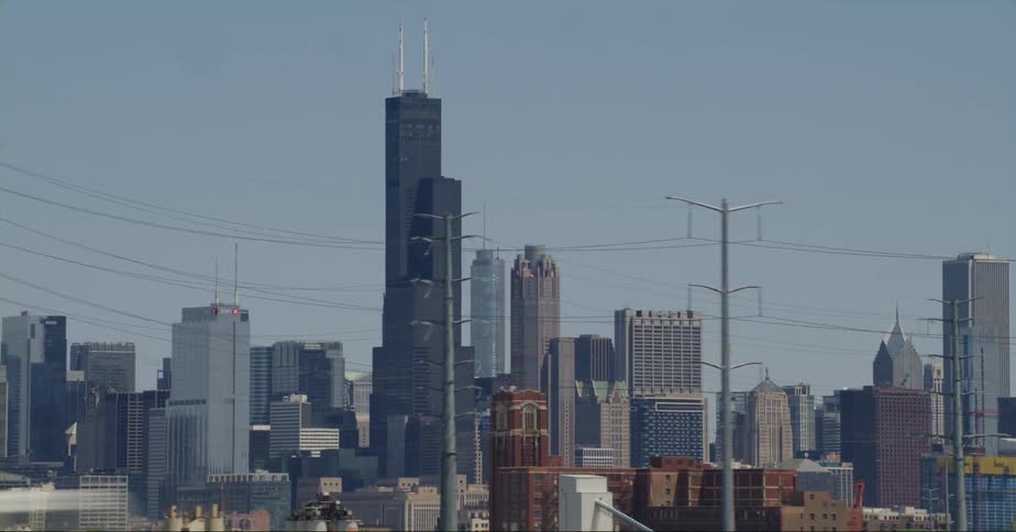 Shipping vehicles driving past a city skyline with high rise office buildings