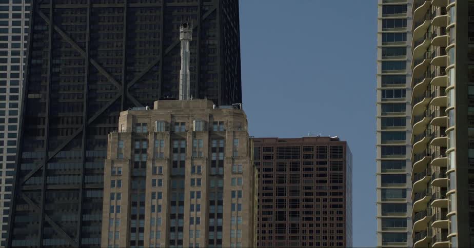 Skyscrapers tower over tall building with crowned metal cylinder