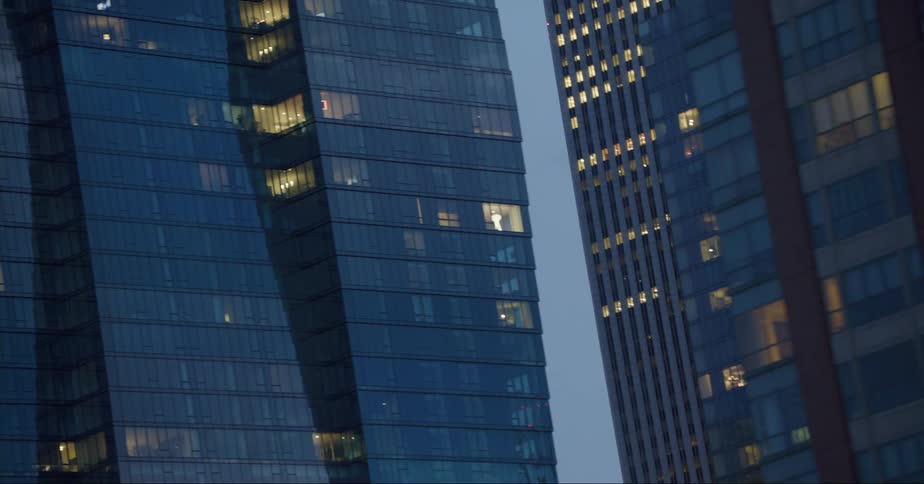 The lights are on in some of the windows of the buildings