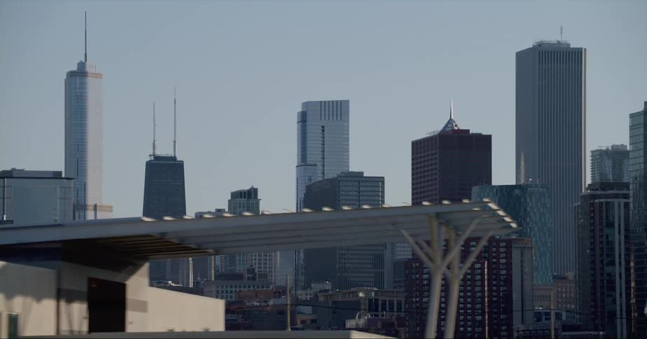 Traffic passes building with flags near downtown skyscrapers