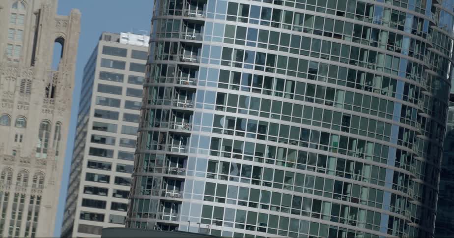 Older building with traditional architecture stands surrounded by downtown skyscrapers