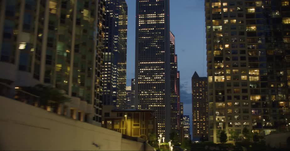 The large buildings are lit up at sunset