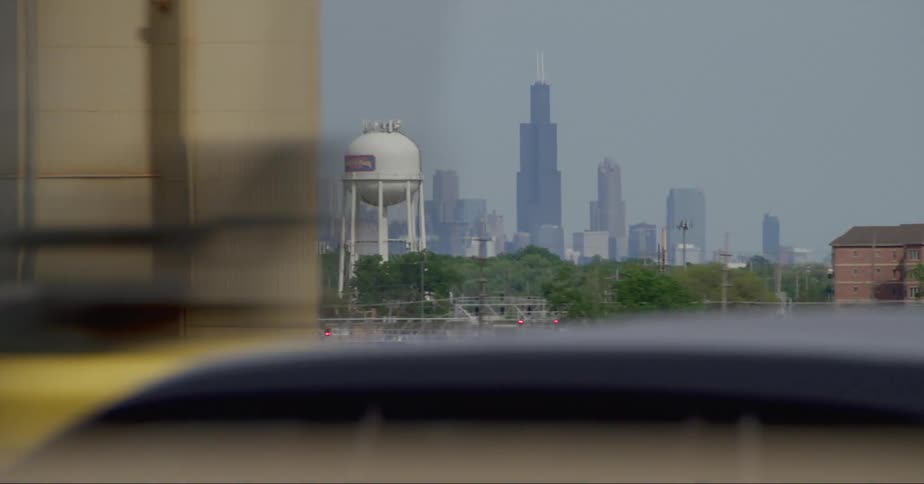 Distant skyscrapers and high rise buildings seen from vehicle driving on highway