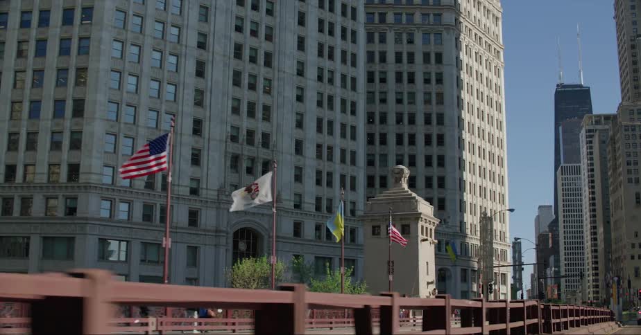 American and municipal flags line a bridge headed toward downtown