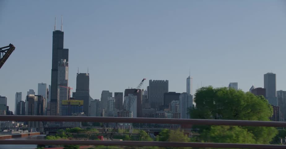 Distant skyscrapers and high rise buildings seen from vehicle driving on highway