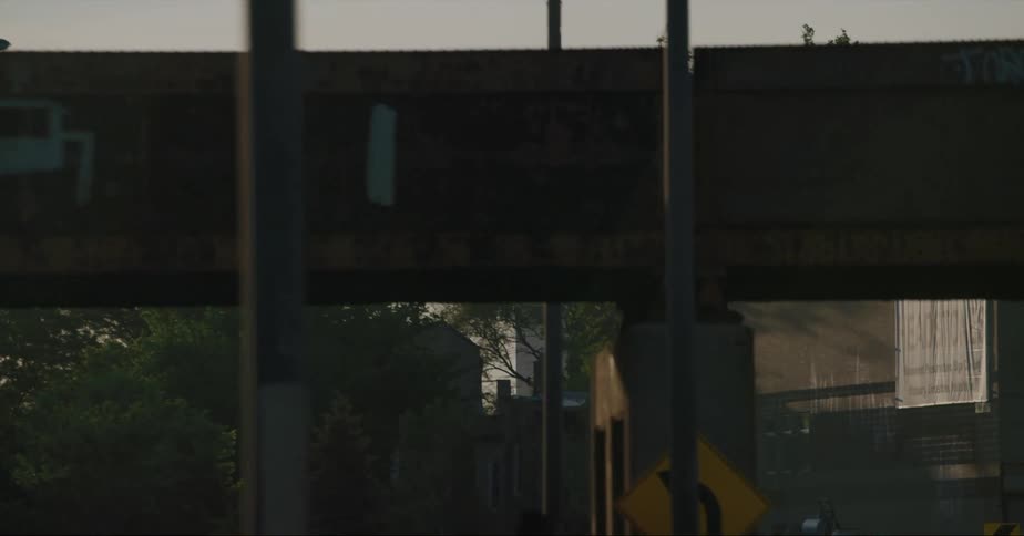 A car traveling on an urban road with a skyscraper in the distance