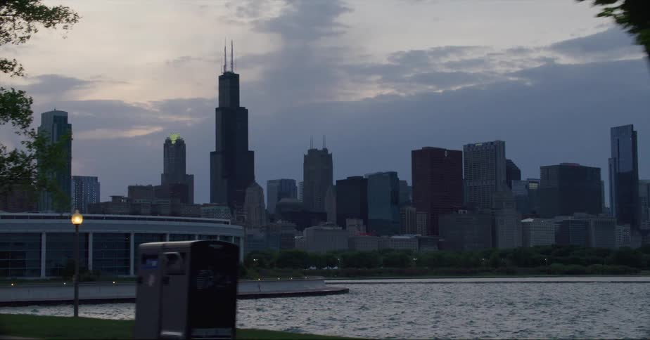 The willis tower on the chicago skyline in front of the coasts of lake michigan at evening