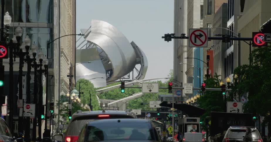 Cars traveling on a chicago city street towards the jay pritzker pavilion
