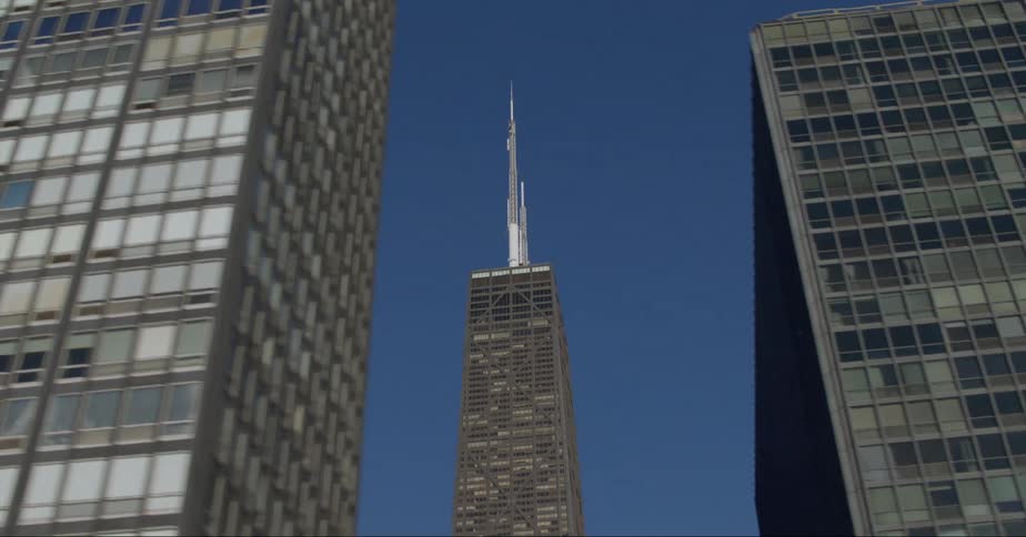 The willis tower behind skyscrapers on the chicago skyline under a deep blue sky