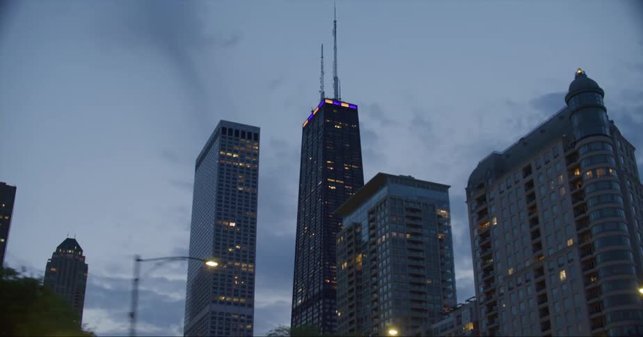 The willis tower behind skyscrapers on the chicago skyline under a deep blue sky at evening