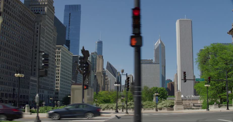 Cars commuting on an urban street with skyscrapers in the distance