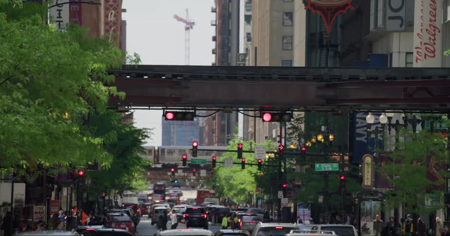 Pedestrians cross the street at a busy intersection against heavy traffic