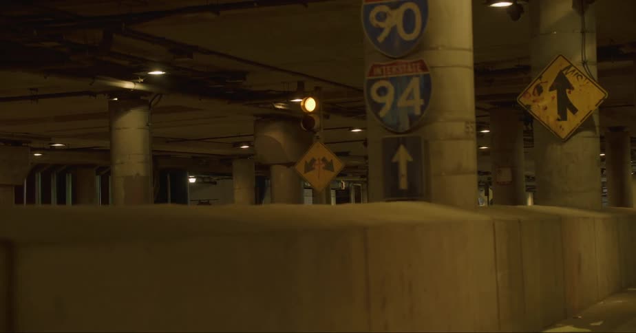 Vehicle moves through concrete structure with support columns
