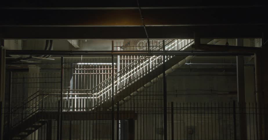 Orbiting footage of an underground staircase surrounded by an iron fence