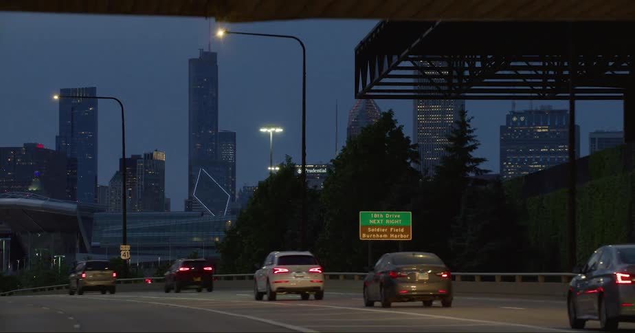 Traffic passes under bridge near downtown at night